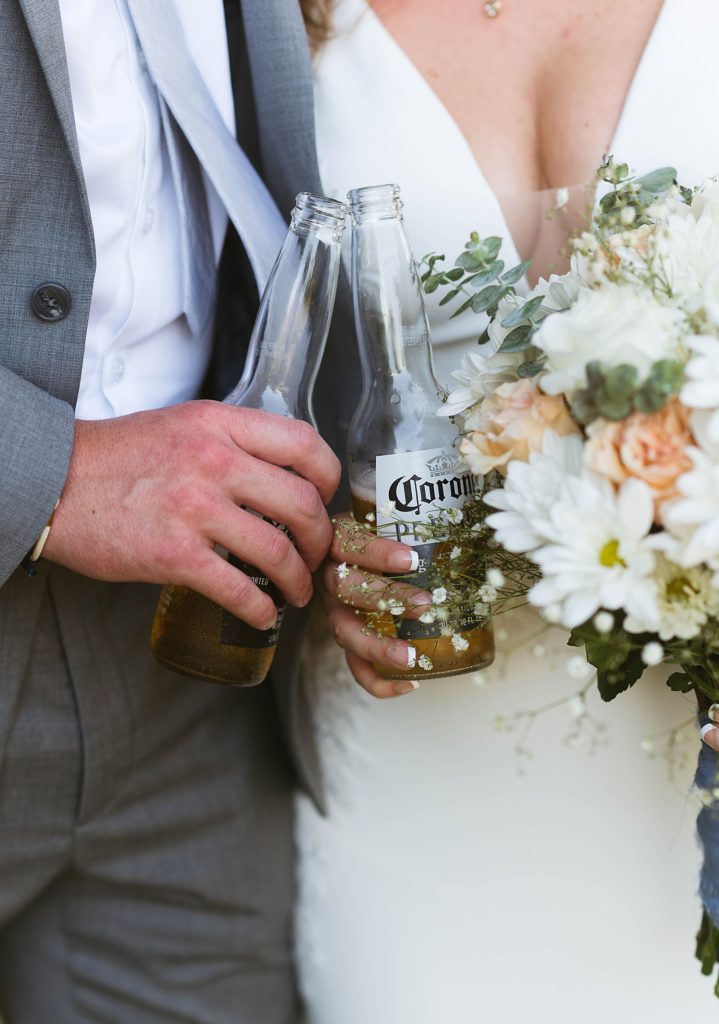 Bride and groom toasting with corona during golden hour portraits