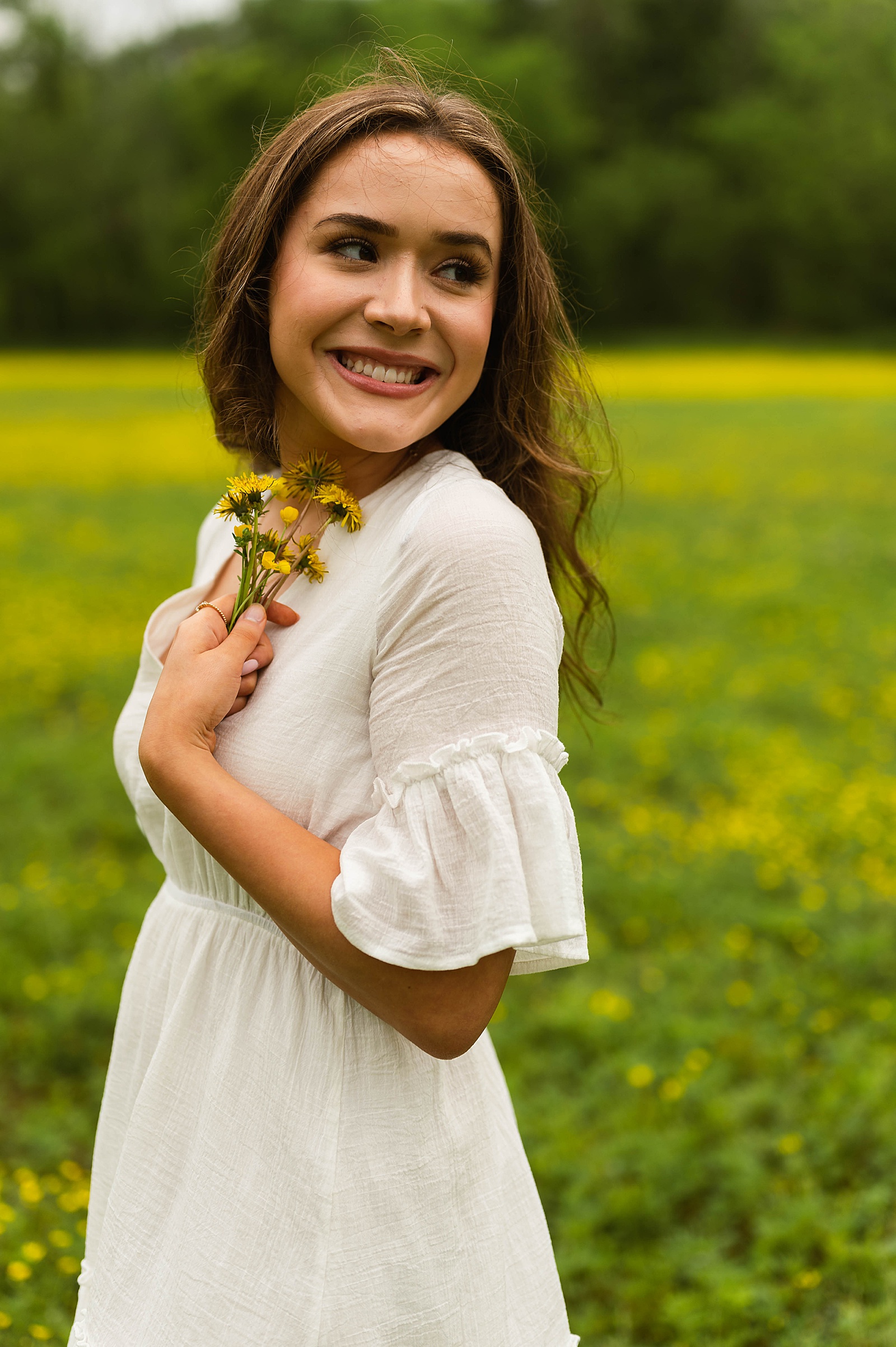 Brunette woman holding yellow flowers by Hannah Louise Photography 