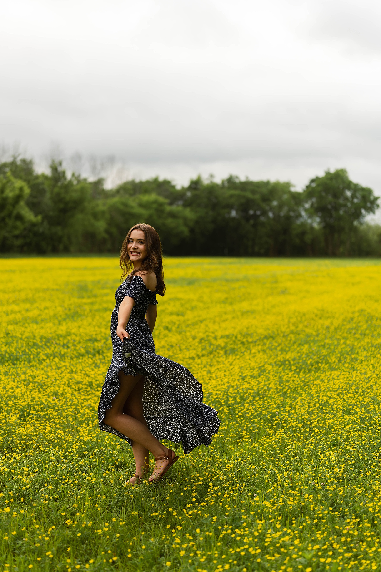 Woman in blue dress dancing in a field for Spring Flowers portraits