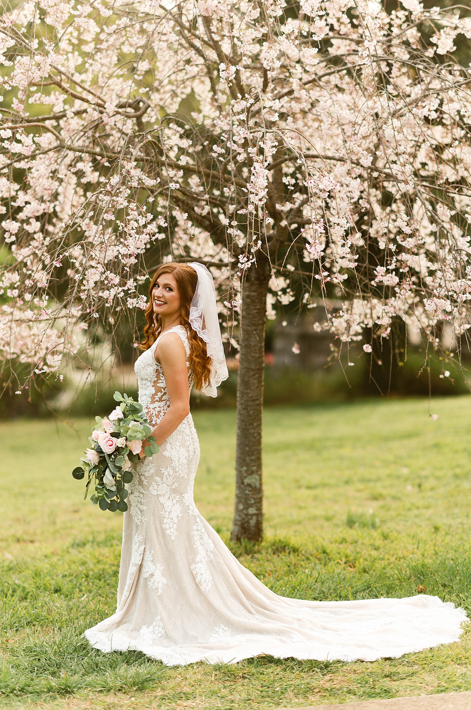 Redhead bride under blossoms in Virginia for Spring Bridals