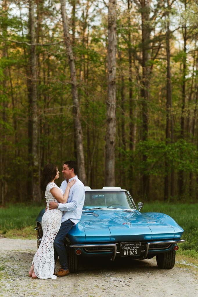 Engaged couple leaning against blue vehicle for vintage car session 