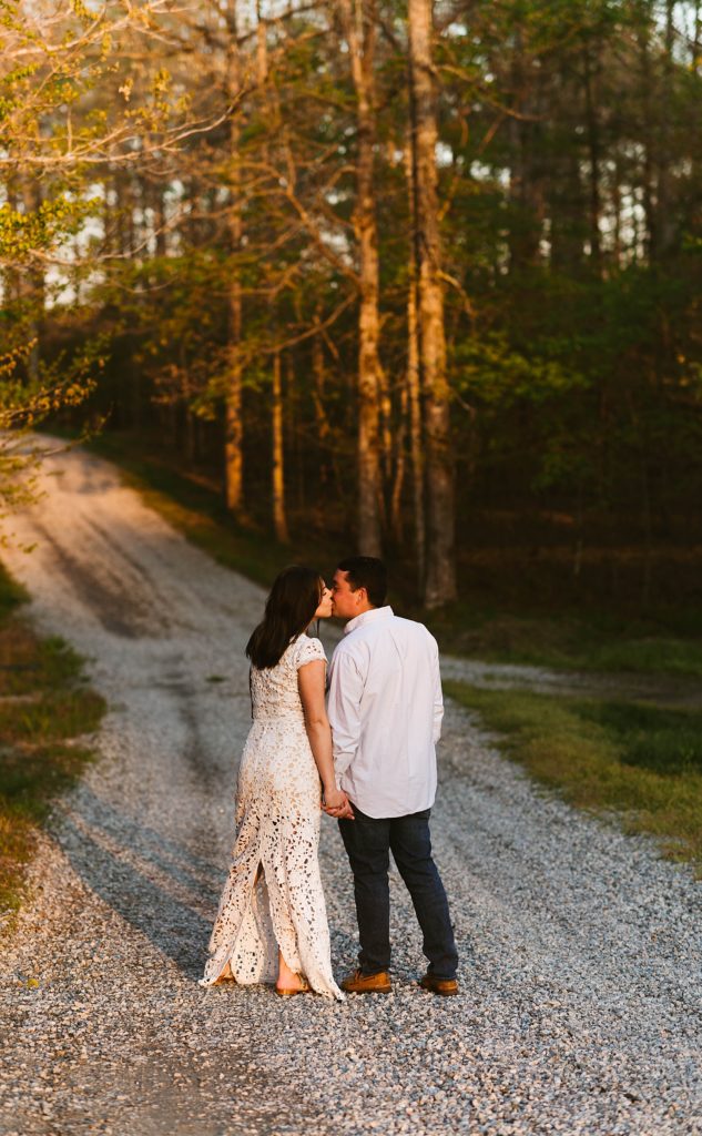 Man and woman kissing in the woods after their vintage car session
