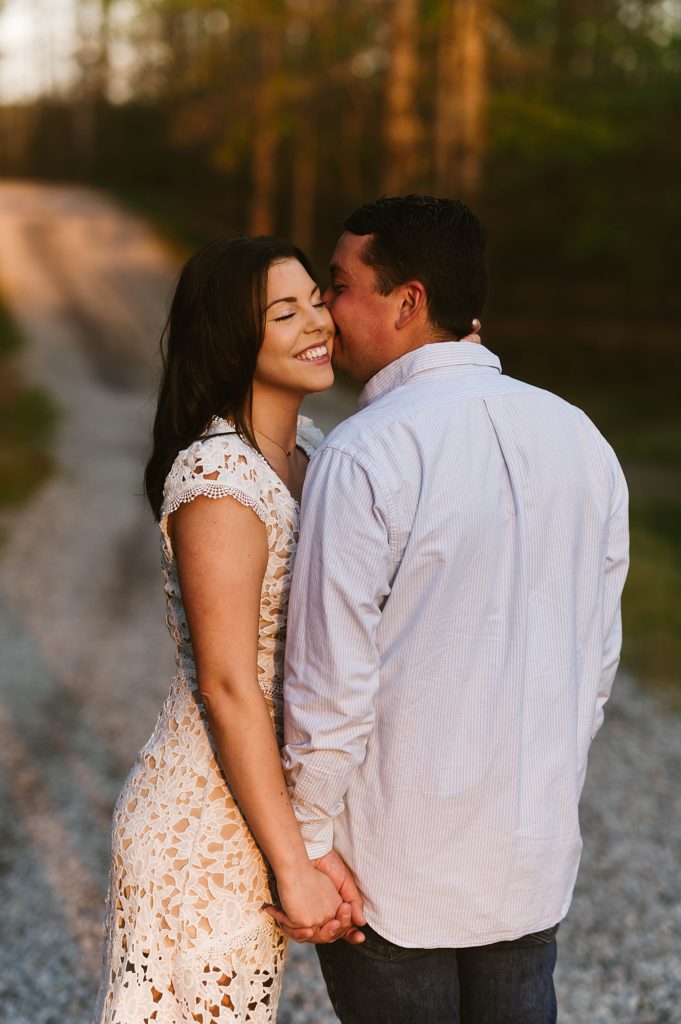 Woman grinning as her man kisses her cheek by Richmond Engagement Photographer 