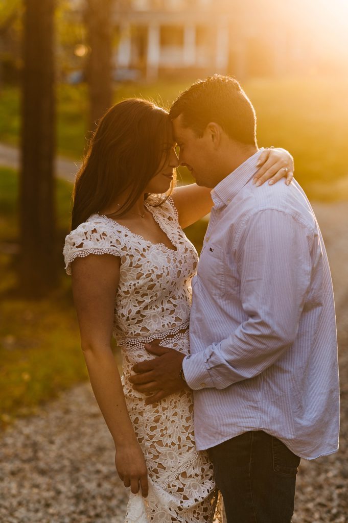 Engaged couple embracing at sunset by Hannah Louise Photo