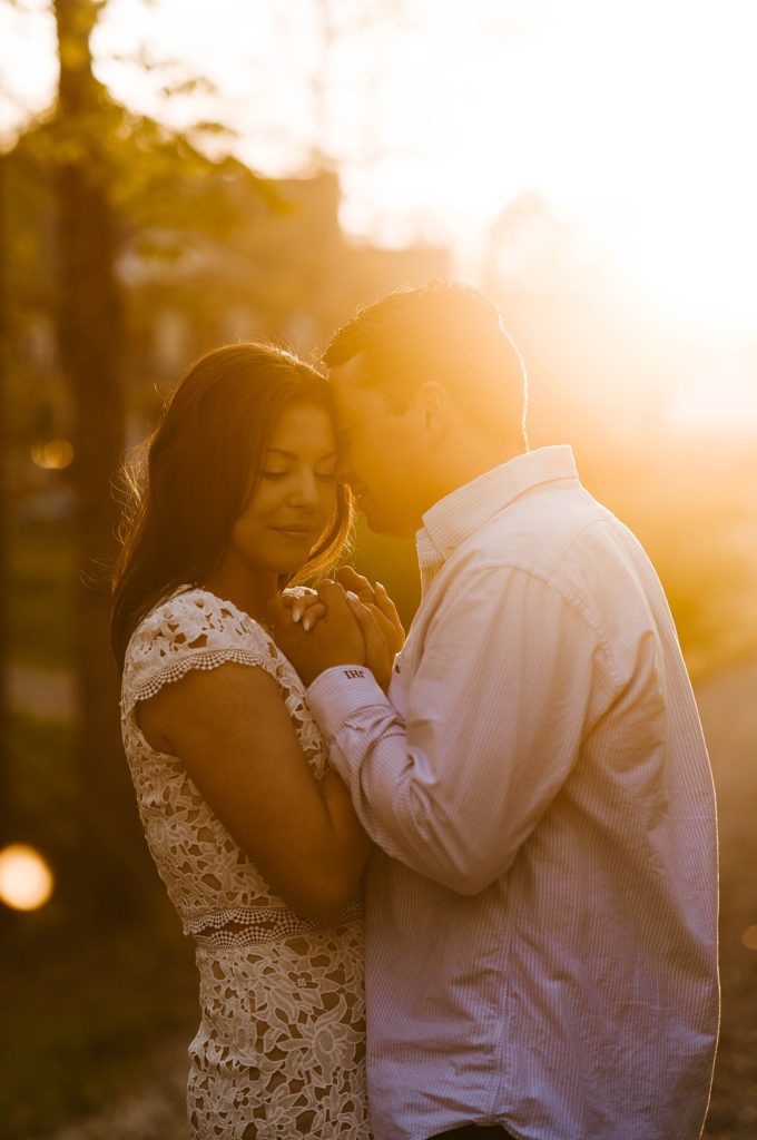 Couple embracing closely in golden light by Hannah Louise Photo
