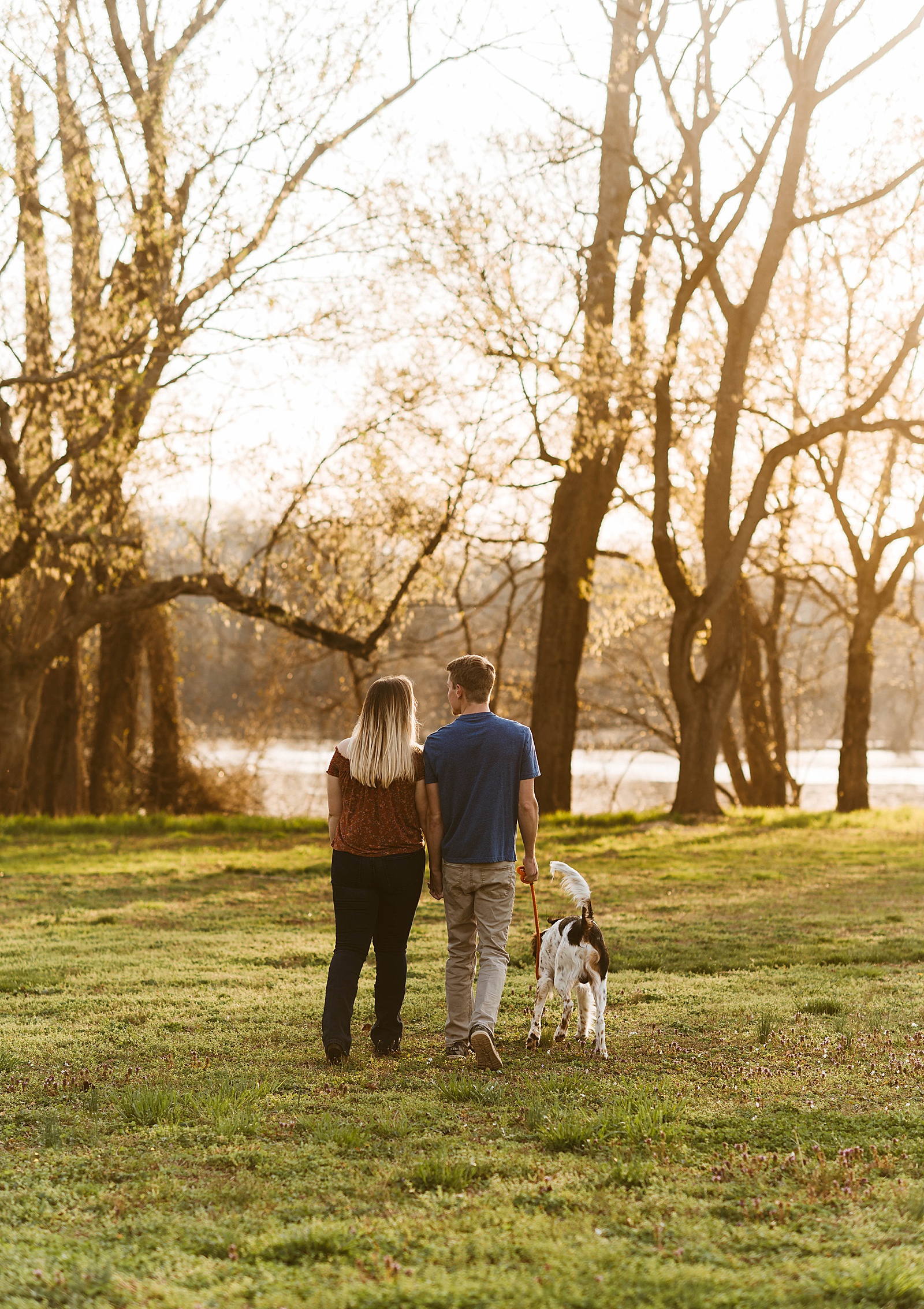 Couple walks towards river for couples shoot with their dog