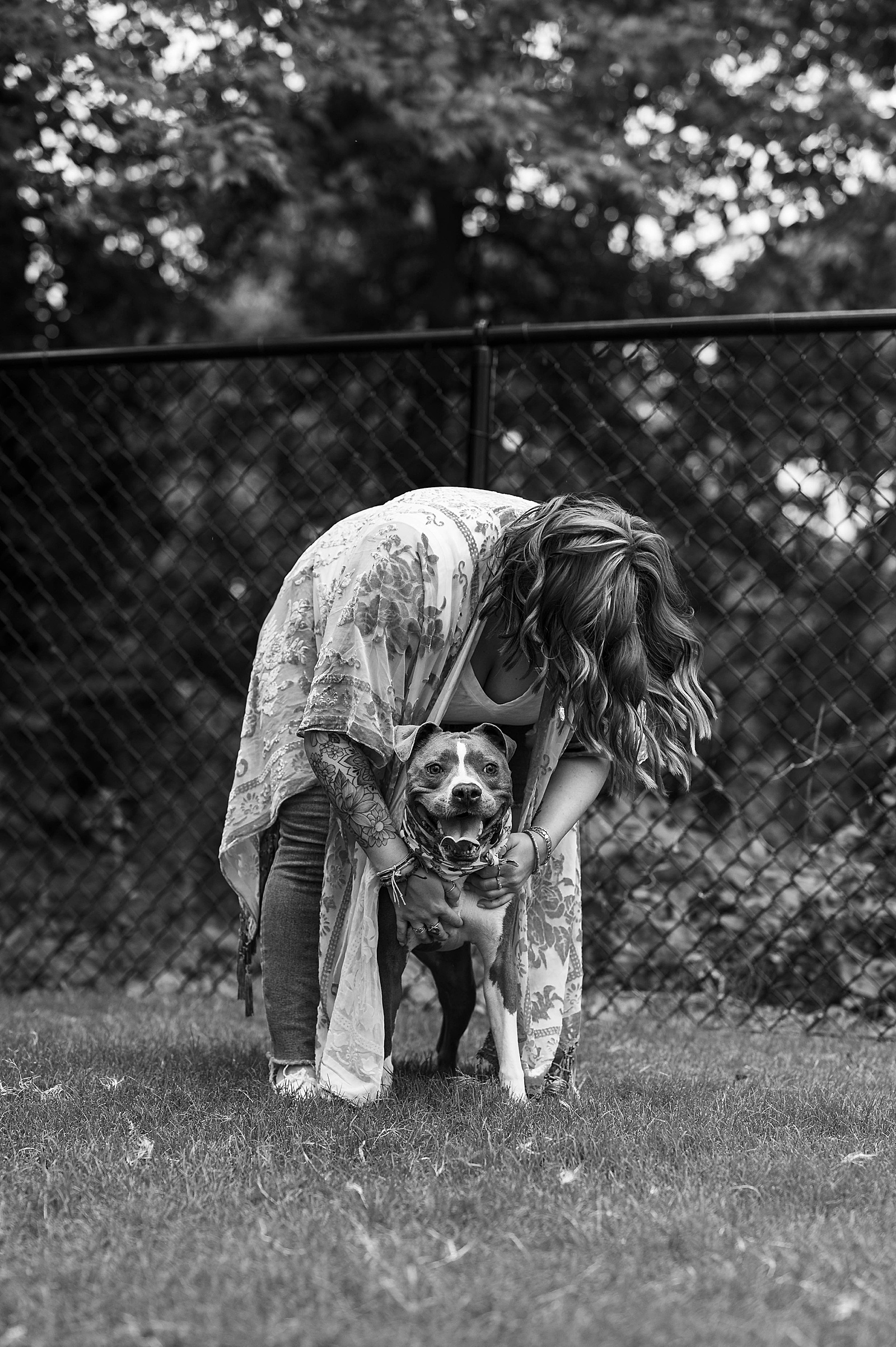 Woman in jeans hugging her dog for photo shoot with pups