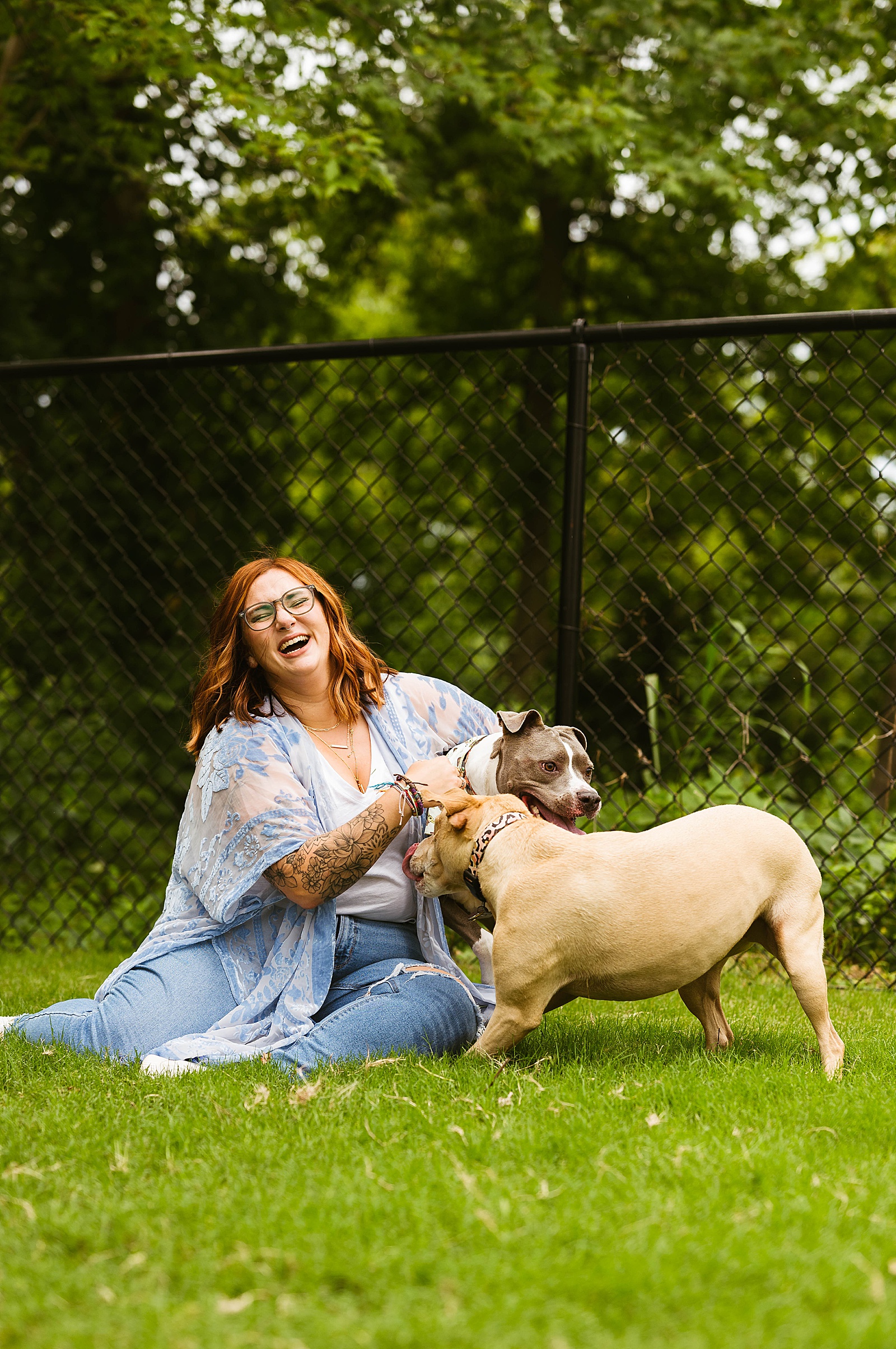 Redhead playing with dogs for photo shoot with pups