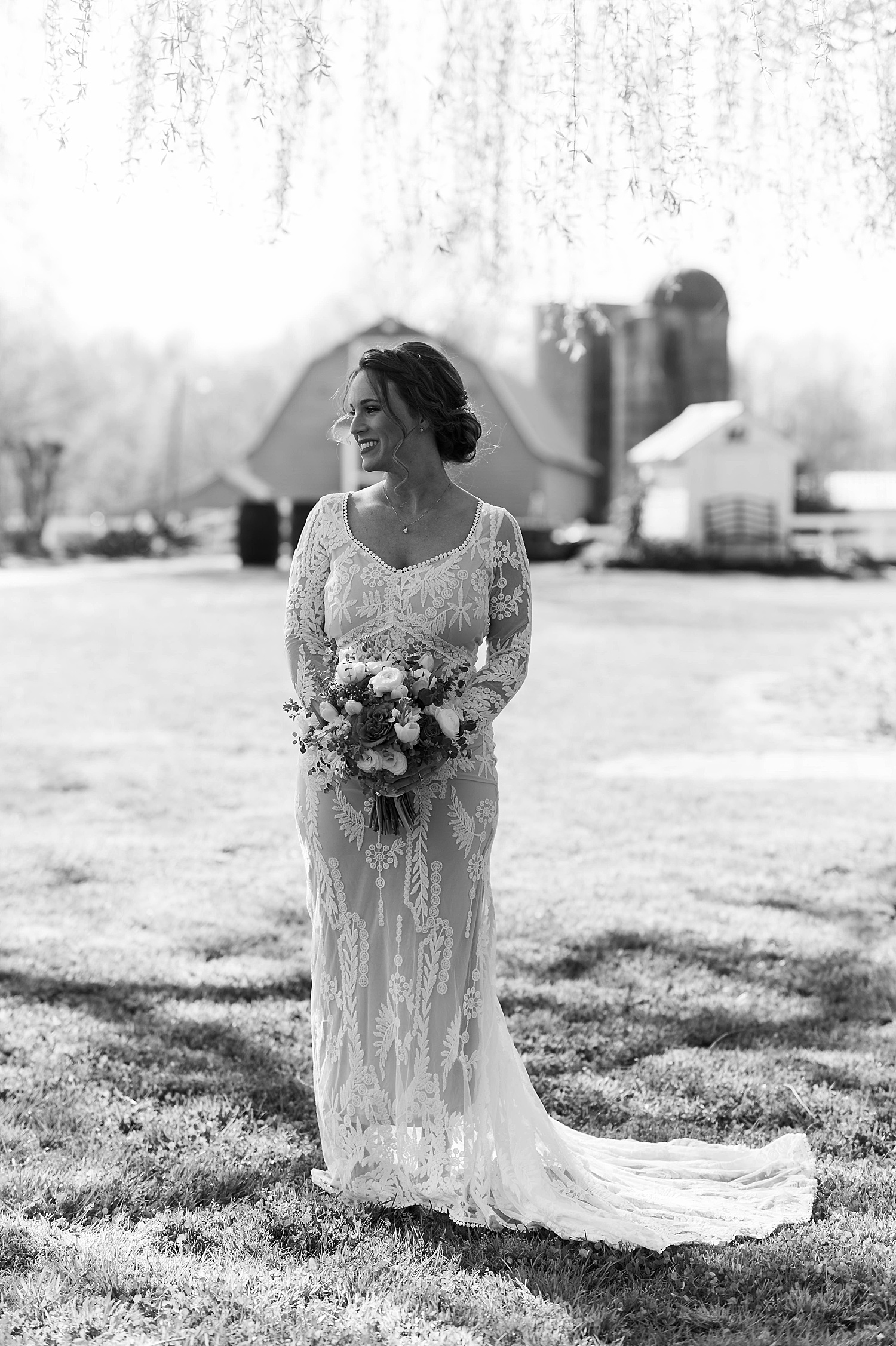 Bride in lace dress holding flowers by Virginia Wedding Photographer 
