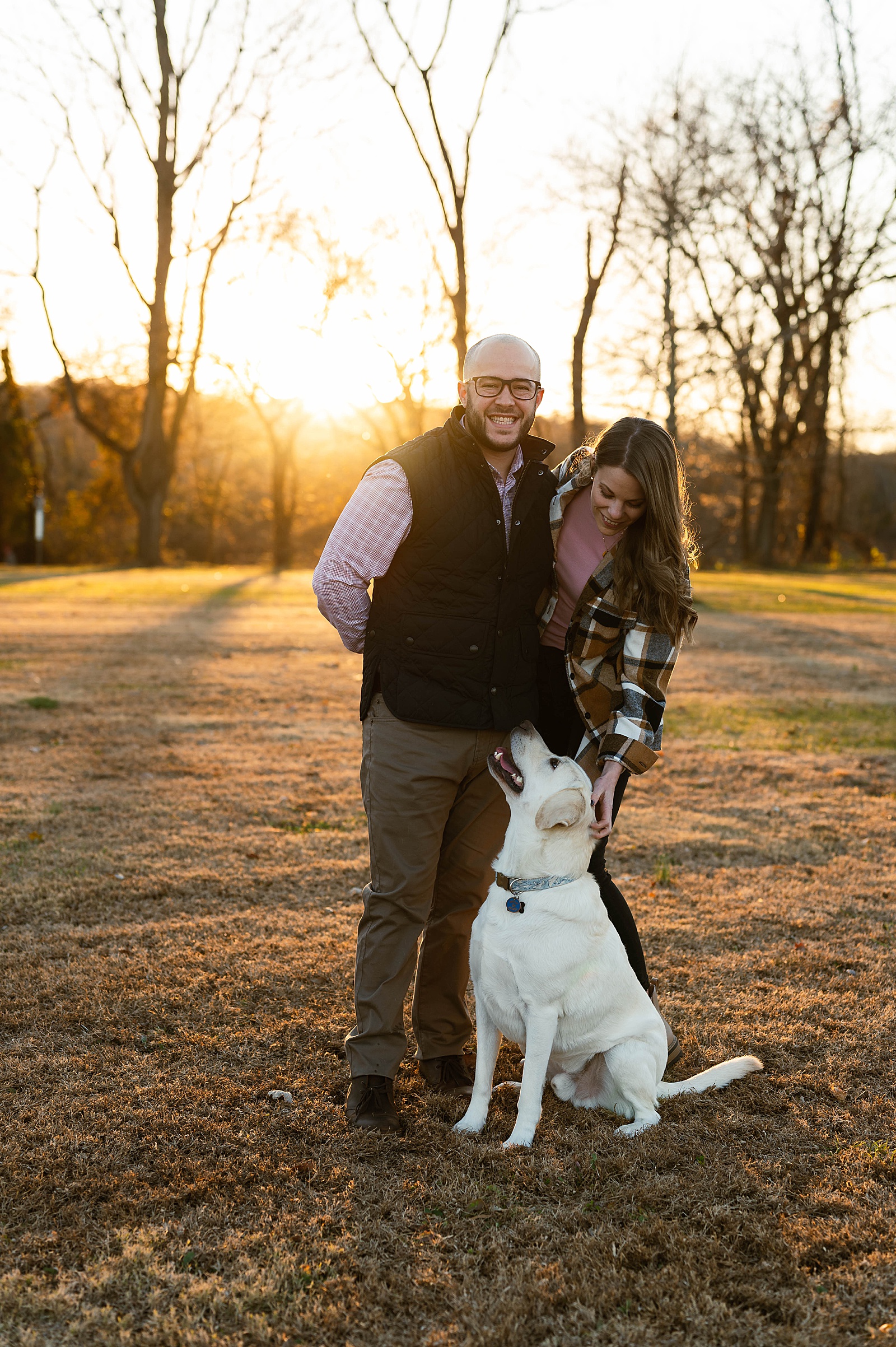 Married couple petting their dog at park by Richmond portrait photographer 