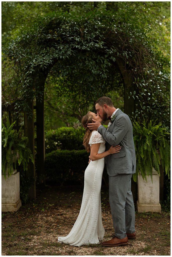 bride and groom kissing under altar by Hannah Louise Photography