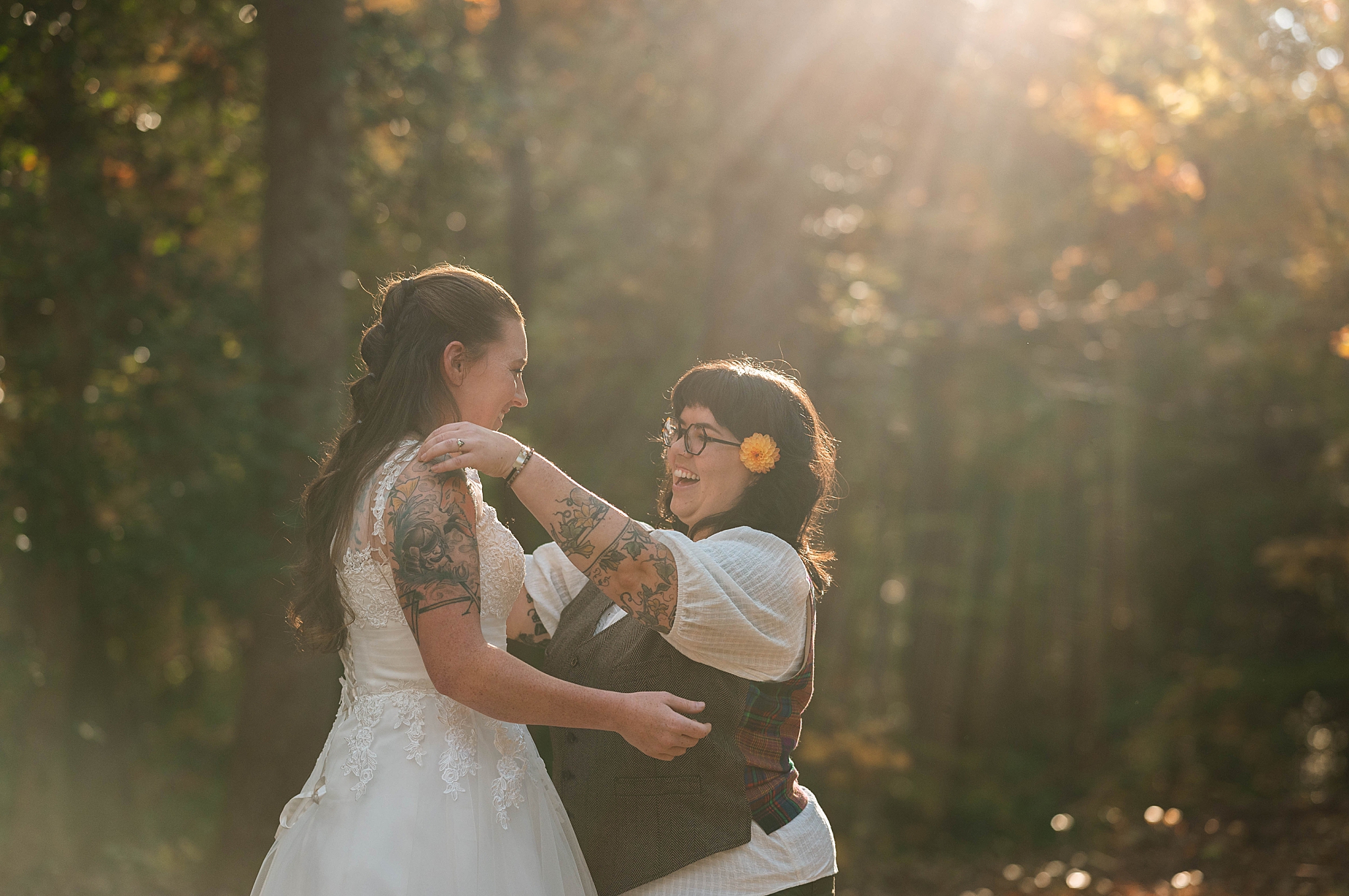 couple reaches for each other as light shines by Hannah Louise Photography