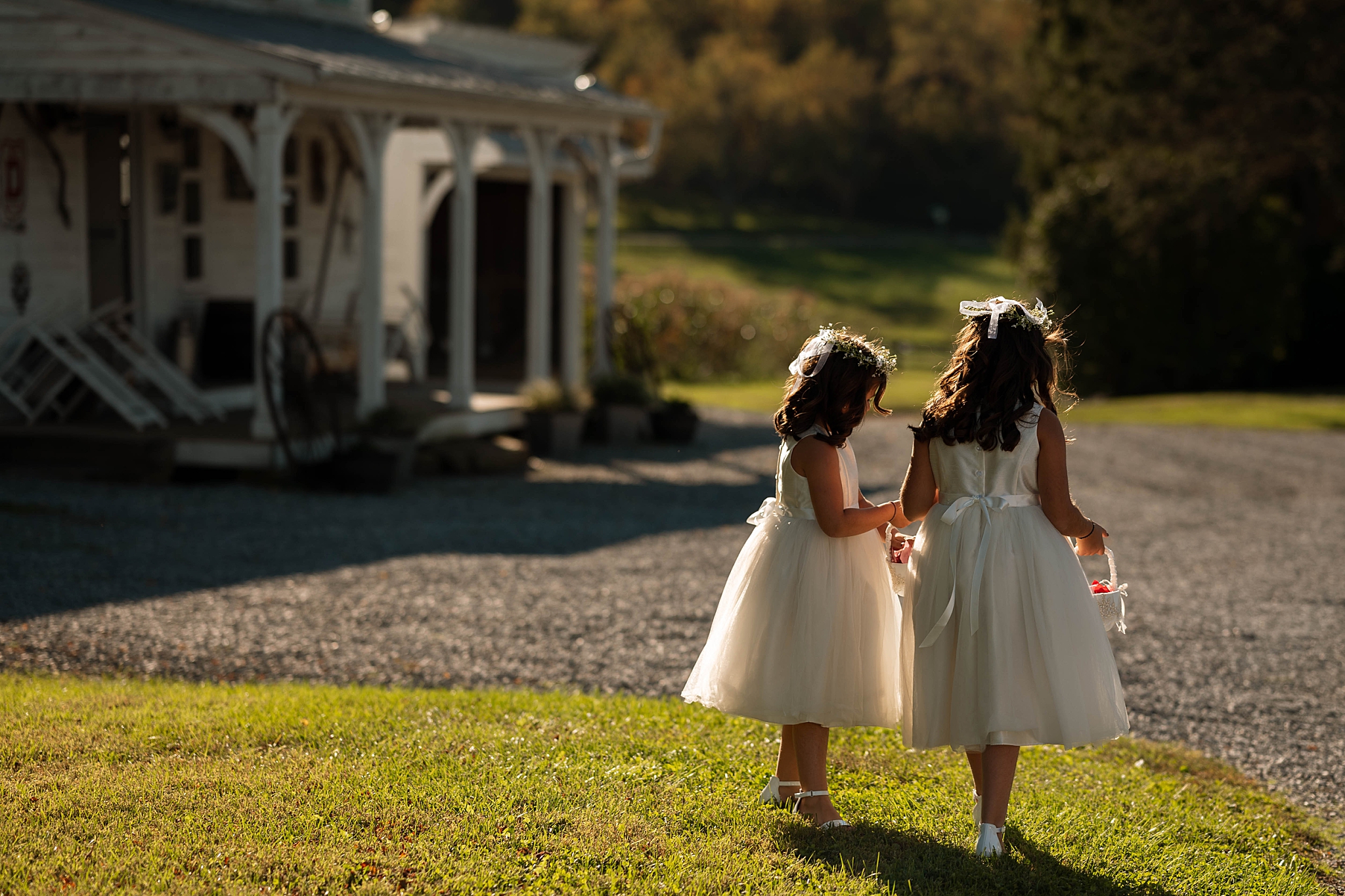 sisters walk together in front of farmhouse by Hannah Louise Photo