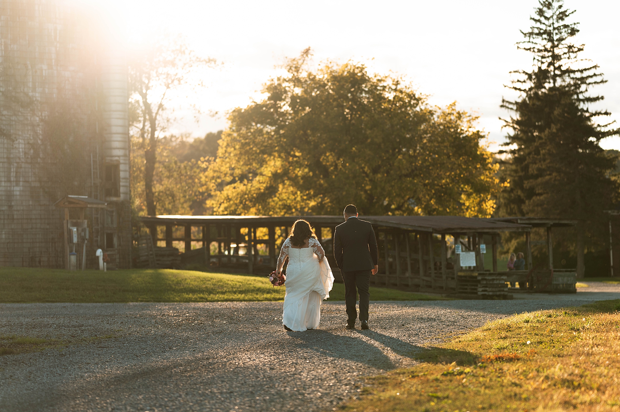 couple walks down road together during golden hour by Hannah Louise Photo